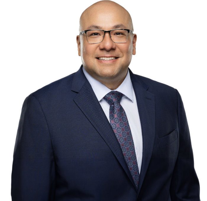 a man in a suit and tie and wearing glasses smiles at the camera, showing the confidence of an experienced divorce lawyer